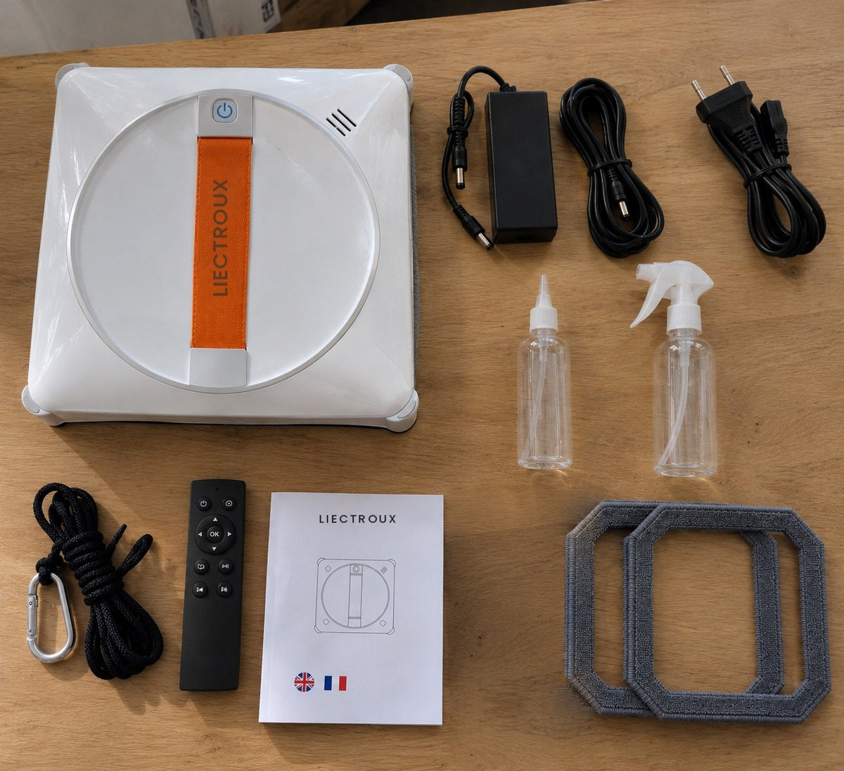 Contenu du colis du Setoriva Premium : robot, télécommande, adaptateur, câble secteur et rallonge, corde de sécurité, 2 chiffons, flacon de remplissage, flacon pulvérisateur et notice Image